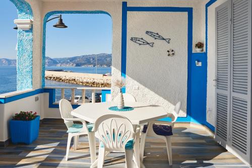 a table and chairs on a balcony with a view of the ocean at B&B AcquaDolce in Cala Gonone