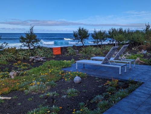 two chairs and a bench on the beach at Casa Baleia Laranja Ocean-Front in Madalena