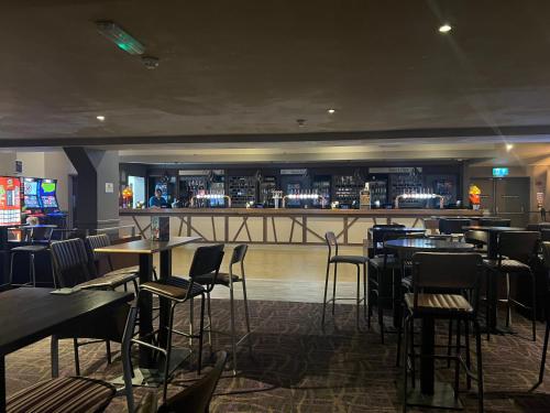 a restaurant with tables and chairs and a bar at Bella-Mays Holiday Hideaway in Lincolnshire