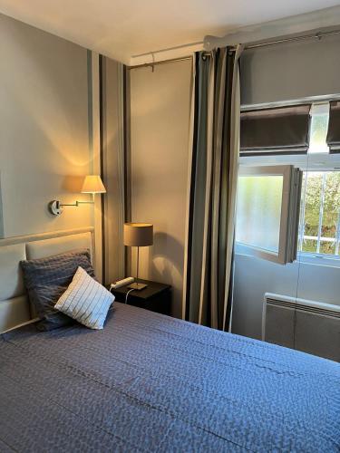 une chambre avec un lit bleu et une fenêtre dans l'établissement Détente à Juan Les Pins 2 Pièces Climatisée à 500m des plages, à Antibes