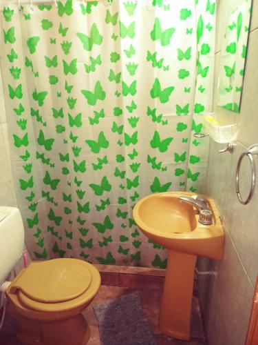 a bathroom with a toilet and a shower curtain with butterflies at Cabañas la calma in Concordia