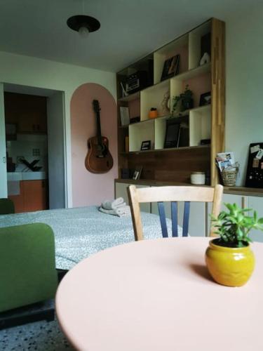 une pièce avec une table et une pièce avec une guitare dans l'établissement Studio indépendant dans un quartier calme à Arles, à Arles
