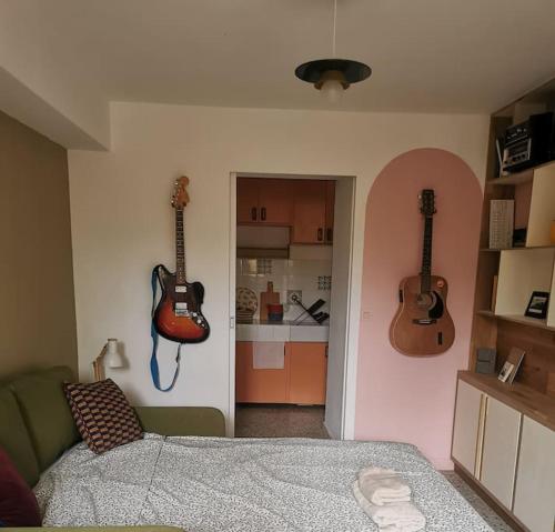 - une chambre avec 3 guitares accrochées au mur dans l'établissement Studio indépendant dans un quartier calme à Arles, à Arles