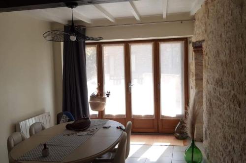 une salle à manger avec une table et une grande porte en verre dans l'établissement maison au cœur du triangle d'or, à Cestayrols