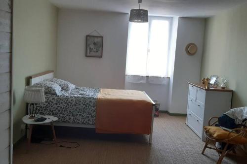 une chambre avec un lit, une table et une fenêtre dans l'établissement maison au cœur du triangle d'or, à Cestayrols