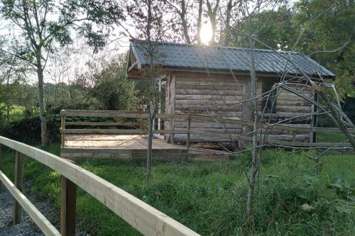 a log cabin with a fence in front of it at Riverside cabin in Limerick