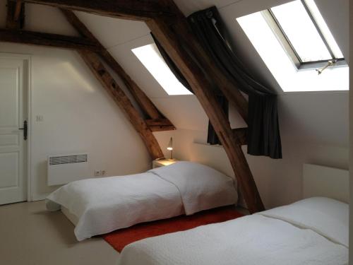 two beds in a attic room with skylights at L'oisellerie Cottages in Le Renouard