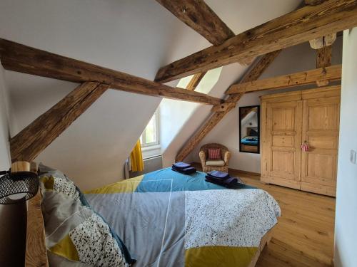 une chambre avec un lit dans un grenier dans l'établissement Chez Jérémie & Mary, à Breitenau