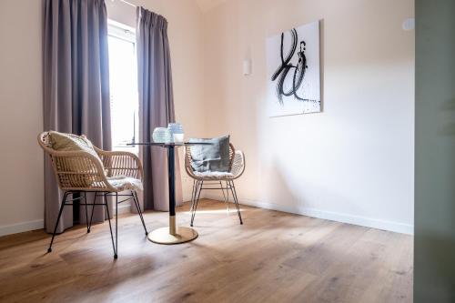 a dining room with two chairs and a table at BB aan de kapel in Roermond