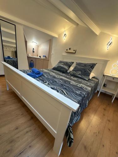 - une chambre dotée d'un grand lit avec un cadre blanc dans l'établissement Duplex proche port de Nice, à Nice