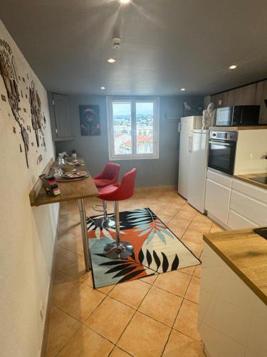 une cuisine avec une table et une chaise rouge sur un tapis dans l'établissement Duplex proche port de Nice, à Nice