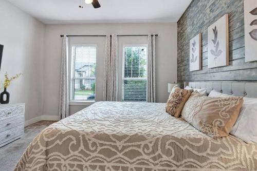 a bedroom with a large bed and two windows at Timeless Beauty in Denton