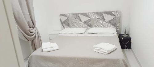 a white bed with two white towels on it at Casa Ser-Ale in Torre Canne