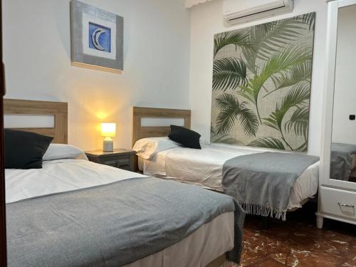 a hotel room with two beds and a mural on the wall at Casa Rural Alora Caminito del Rey in Alora