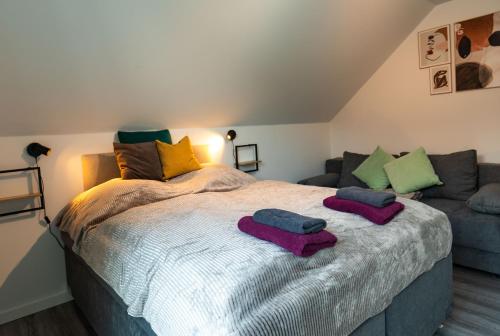 a bedroom with a bed with two towels on it at HeideFunHaus 2 in Neuenkirchen
