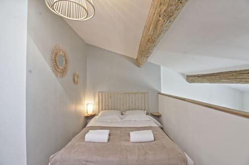 une chambre avec un lit avec deux serviettes dessus dans l'établissement Le Plaisant - Nîmes plein centre, à Nîmes