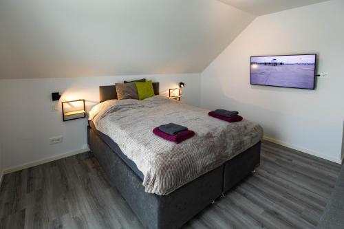 a bedroom with a large bed with two towels on it at HeideFunHaus 2 in Neuenkirchen