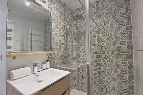 une salle de bain blanche avec un lavabo et une douche dans l'établissement Le Plaisant - Nîmes plein centre, à Nîmes