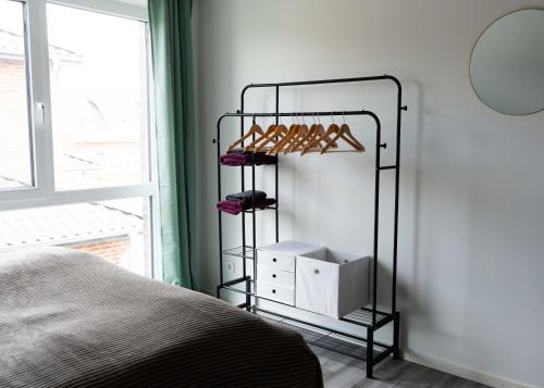 a bedroom with a black rack with shoes at HeideFunHaus 2 in Neuenkirchen