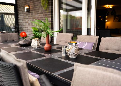 a table with chairs and vases on top of it at HeideFunHaus 2 in Neuenkirchen