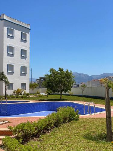 a swimming pool in front of a building at Résidence riad sofia in Martil