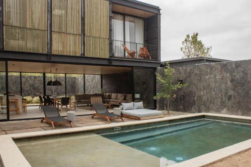 a house with a swimming pool in front of it at Hotel Cuatro Cuatros in Ensenada