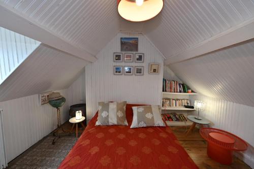 - une chambre mansardée avec un lit rouge dans l'établissement la maison de Domi, à Trouville-sur-Mer