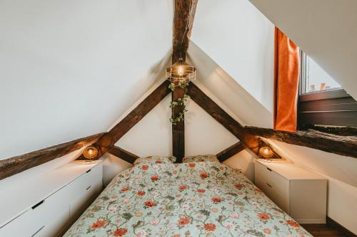 une chambre avec un lit dans un grenier dans l'établissement La canopée Dijonnaise Confort Centre Ville, à Dijon