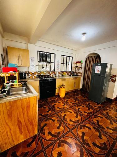 a kitchen with a sink and a refrigerator at LA CASONA SV Hostal in La Libertad