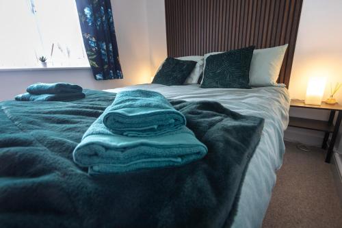 a bedroom with a bed with blue towels on it at Hampton 3-bedroom Relaxing Escape with Parking in Peterborough
