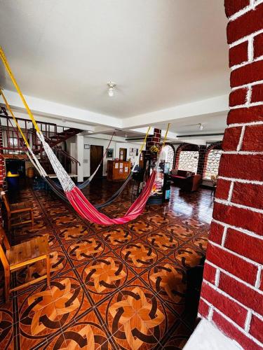 a room with a hammock and a brick wall at LA CASONA SV Hostal in La Libertad