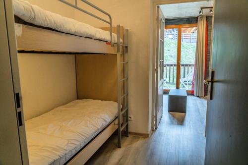 Cette chambre comprend 2 lits superposés et une porte. dans l'établissement Résidence Les Terrasses Du Soleil D'or - Studio chaleureux au pieds des pistes MAE-1281, aux Orres
