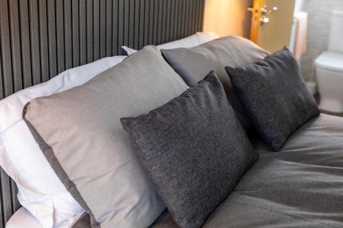 a pile of pillows on top of a bed at Hampton 3-bedroom Relaxing Escape with Parking in Peterborough