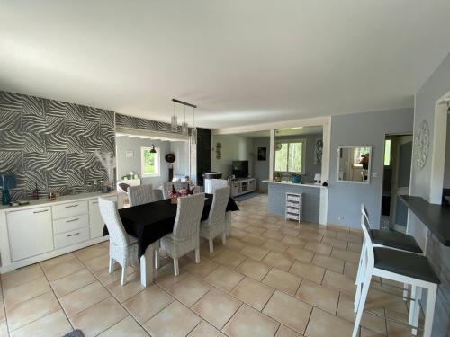 une cuisine et une salle à manger avec une table et des chaises dans l'établissement Maison 5 chambres proche du circuit des 24h du Mans Proche ARNAGE,, à Guécélard