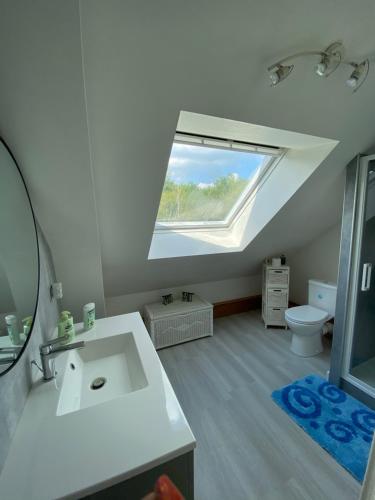 GuécélardにあるMaison 5 chambres proche du circuit des 24h du Mans Proche ARNAGE,の白い洗面台と窓のあるバスルーム