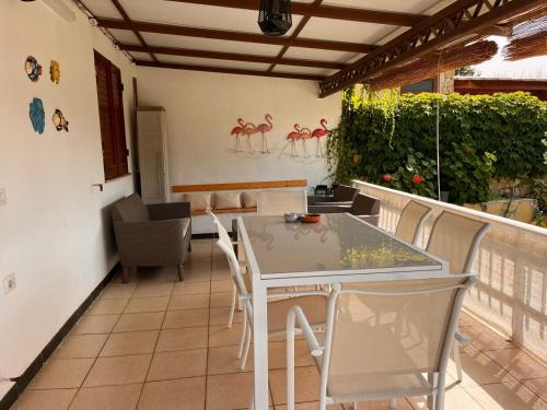a patio with a table and chairs on a balcony at Casa Stewart - Ponente in Geremèas