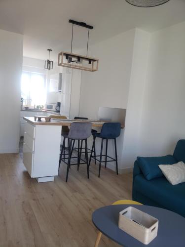 un salon avec une table et un canapé bleu dans l'établissement Appartement chez Virginie et Freddy, à Abbeville
