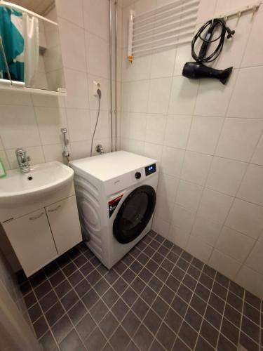 a washing machine in a bathroom with a sink at Studio at Koulukatu in Savonlinna