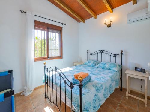 a bedroom with a bed with a blue comforter at Cubo's Finca Tallulah in Villafranco de Guadalhorce