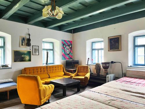 a living room with a couch and chairs in it at Modrá chalupa in Pliešovce