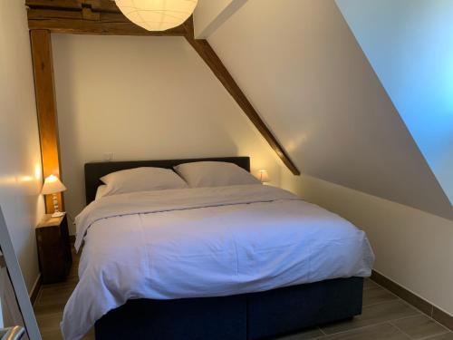 a bedroom with a large bed in a attic at LE CLOCHER " Sous les combles" PARKING GRATUIT in Beblenheim