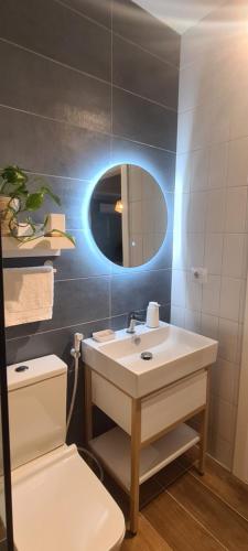 a bathroom with a sink and a mirror and a toilet at LA Comfy AP in Sarandë