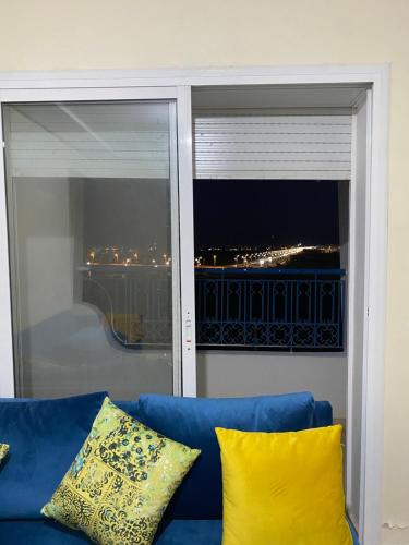 a blue couch in front of a window with a view at Résidence riad sofia in Martil