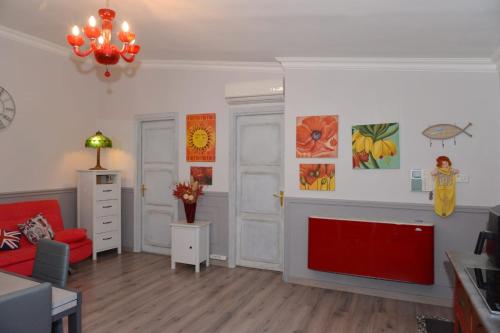 a living room with a red couch and a red chair at Casetta Valderoa Fiumicino in Fiumicino
