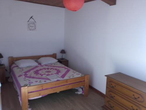 une petite chambre avec un lit et une commode en bois dans l'établissement Maison avec piscine, à Aubenas