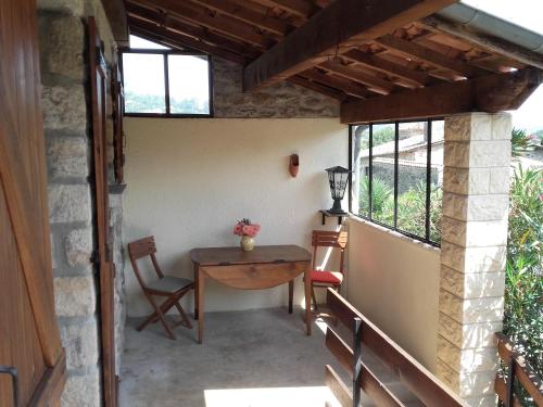 un patio avec une table, des chaises et des fenêtres dans l'établissement Maison avec piscine, à Aubenas