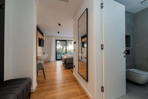 ein Badezimmer mit einem großen Spiegel und ein Schlafzimmer in der Unterkunft Villa Ardura in Zaton