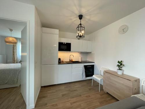 une cuisine avec des armoires blanches et un lit dans une chambre dans l'établissement Apartment near to Paris CDG, à Aulnay-sous-Bois