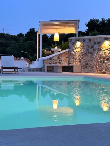 a swimming pool at night with lights in the water at Villa Koukounaria in Skopelos Town