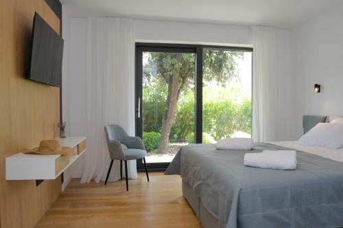 ein Schlafzimmer mit Bett, Schreibtisch und Fenster in der Unterkunft Villa Ardura in Zaton